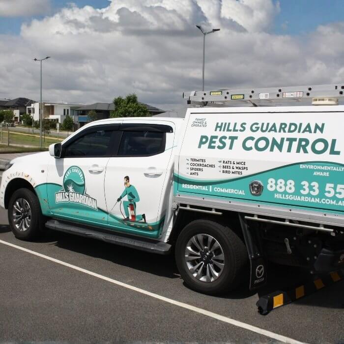 A Hills Guardian Pest Control mobile truck is prominently displayed, representing professional services and a reliable cockroach killer.
